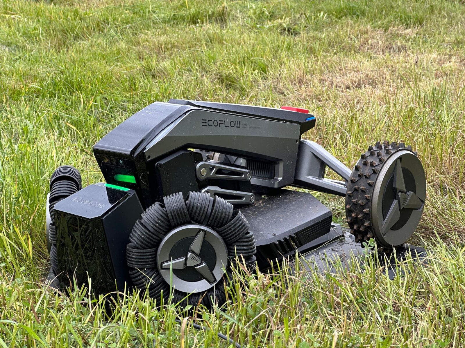 Le robot tondeuse à gazon autonome Ecoflow Blade posé dans un jardin verdoyant.