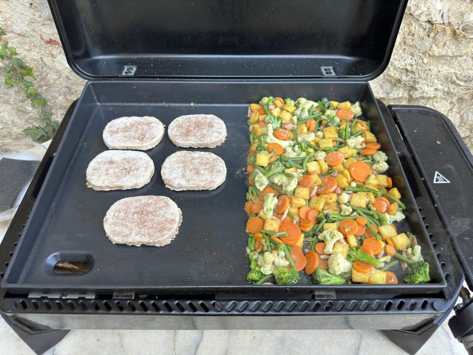 Légumes grillés et burgers cuisinés simultanément sur la plancha