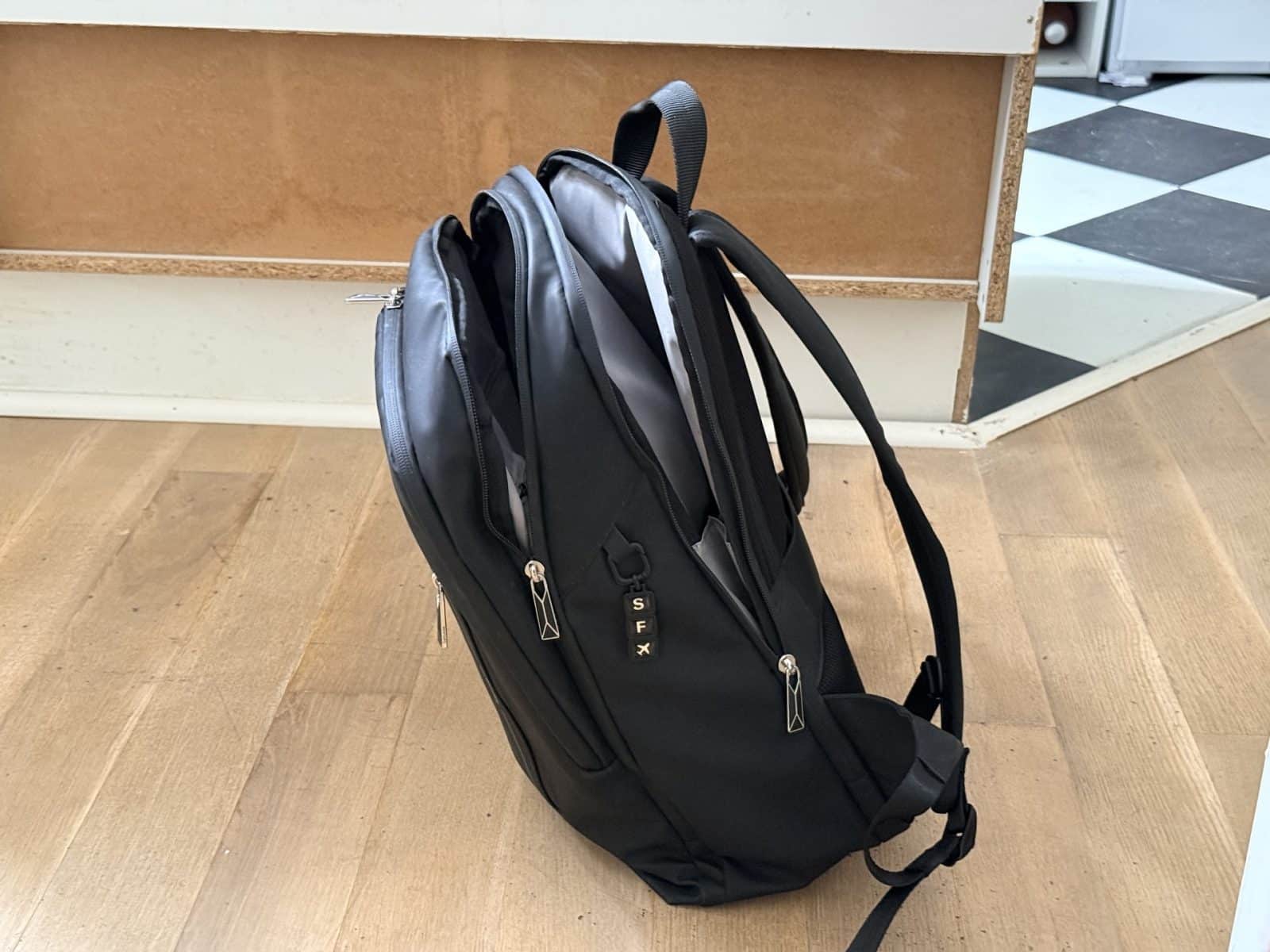Le Samsonite GLAM-GO 15.6 noir qui penche vers l'avant, posé au sol