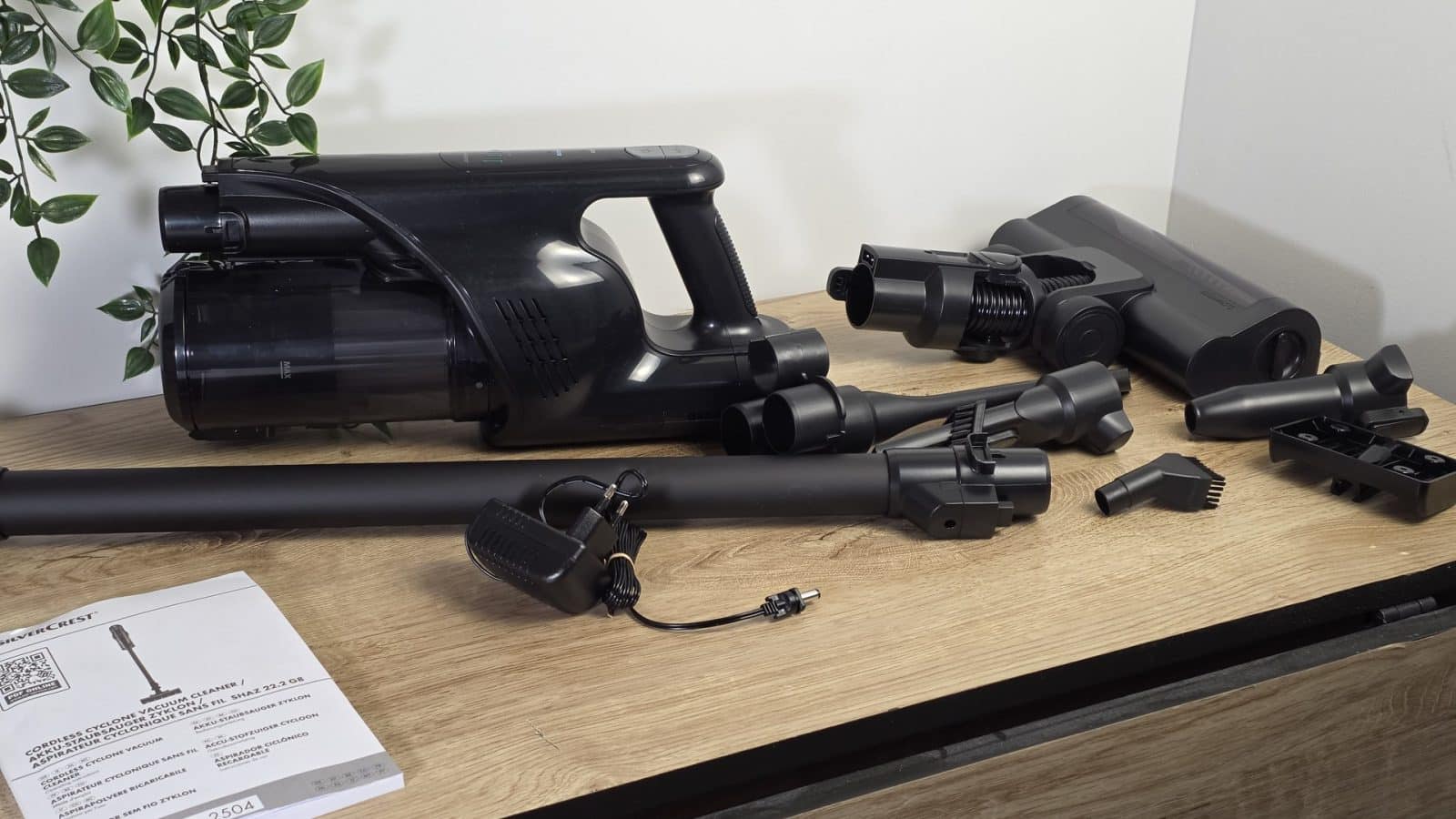 Bloc moteur, tubes et brosses de l'aspirateur SilverCrest étalés sur une table