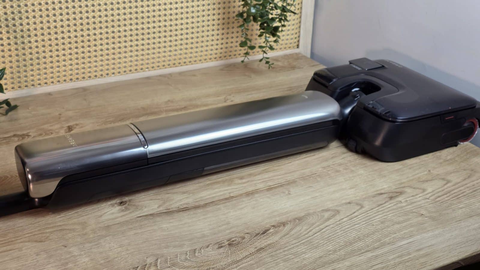 Le Dreame T16 Pro Heat couché à plat sur le sol, à côté de sa base