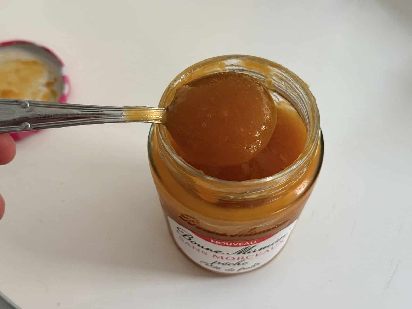 Texture lisse de la Bonne Maman sans morceaux pêche sur une cuillère