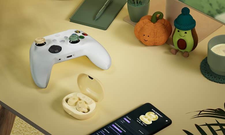 Manette Xbox avec grip Matcha, boitier des Arctis GameBuds coloris Yuzu ouvert, smartphone et decorations d'automne