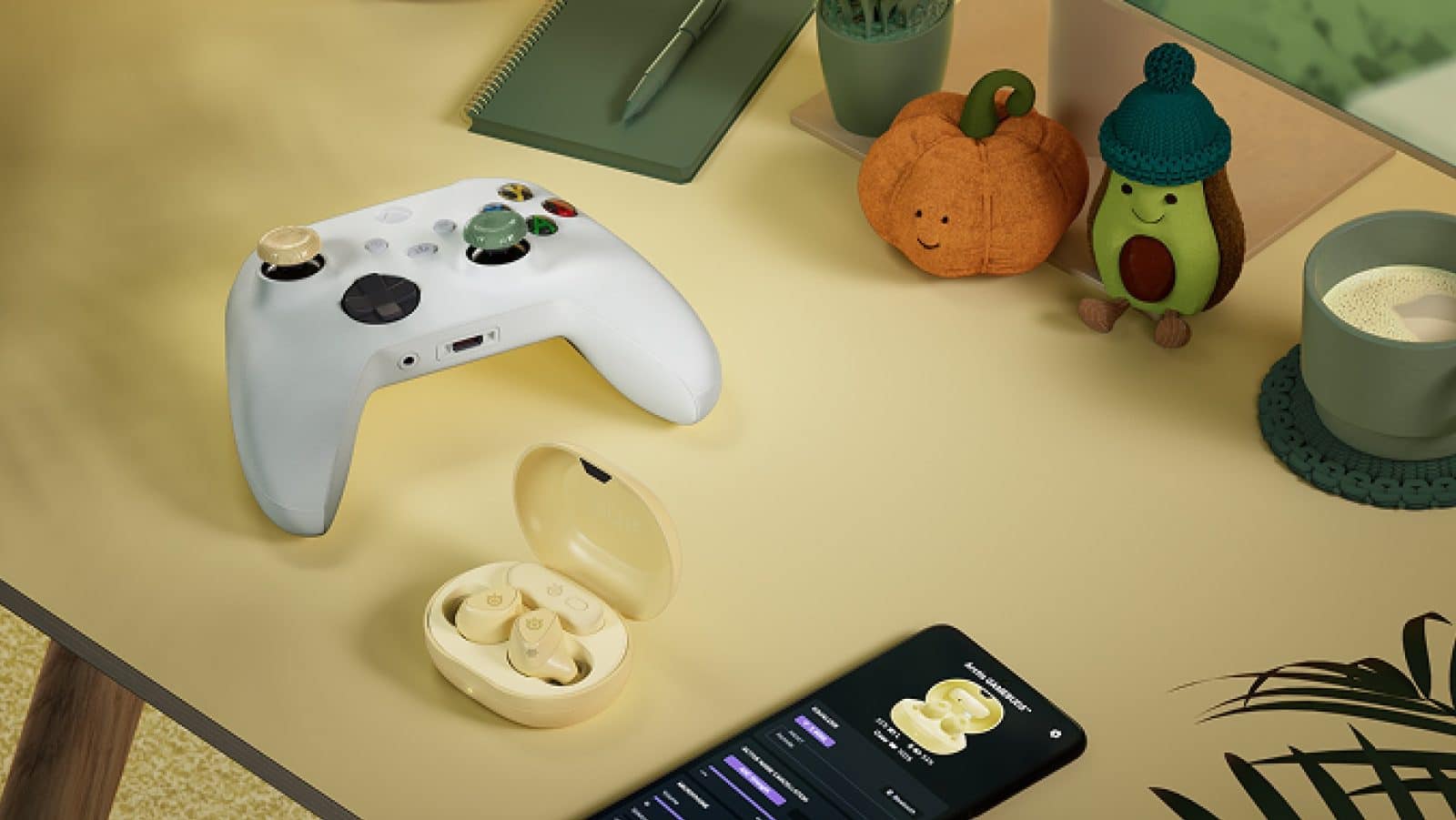 Manette Xbox avec grip Matcha, boitier des Arctis GameBuds coloris Yuzu ouvert, smartphone et décorations d'automne